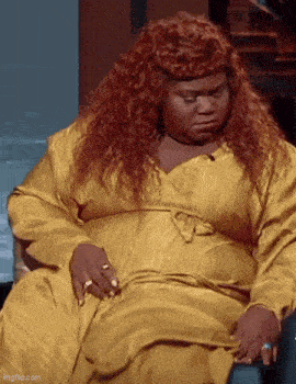 A GIF of a woman sitting down and asking if the couch she's on is cake from 'The Prank Panel'
